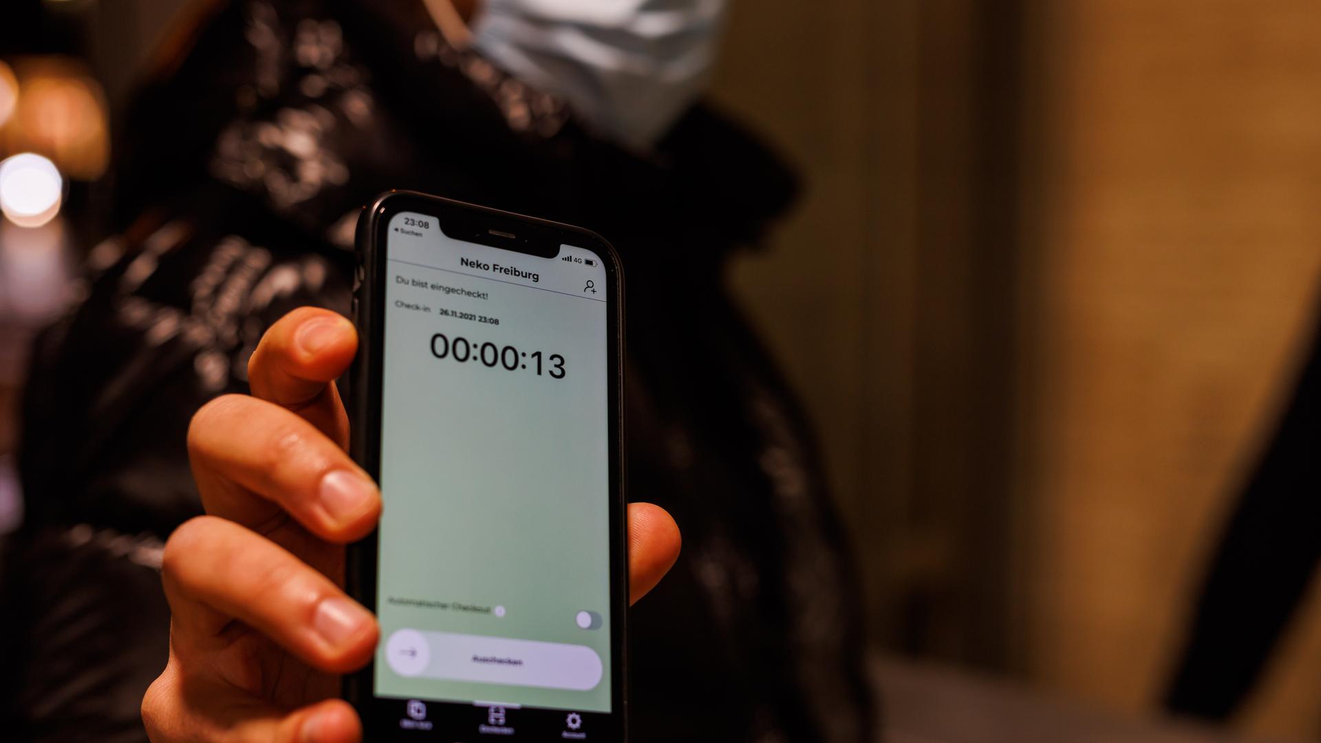 Ein Besucher eines Clubs hat mit der Luca-App auf seinem Smartphone einen QR-Code gescannt, um in einem Club einzuchecken. Ein Besucher eines Clubs hat mit der Luca-App auf seinem Smartphone einen QR-Code gescannt, um in einem Club einzuchecken.