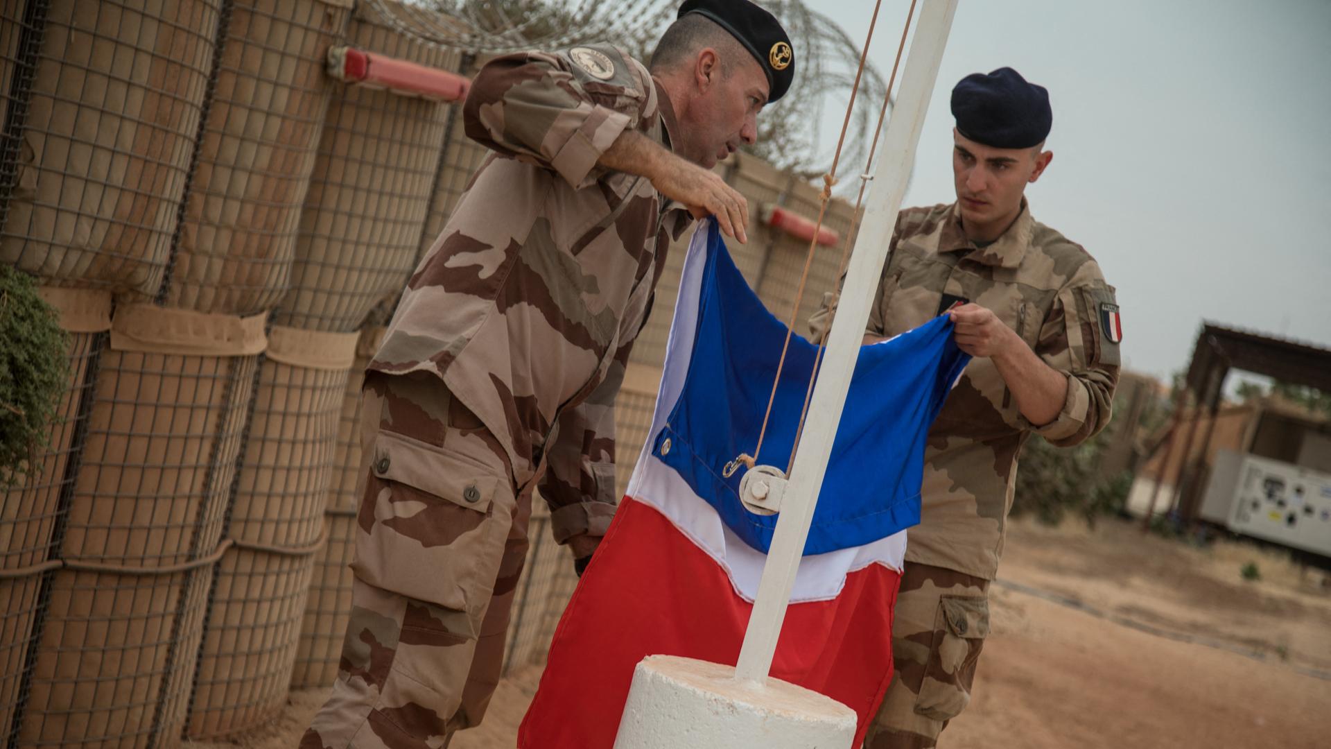 Ein französischer Soldat der Barkhane-Operation beim Einholen der französischen Flagge im Dezember 2021 Ein französischer Soldat der Barkhane-Operation beim Einholen der französischen Flagge im Dezember 2021