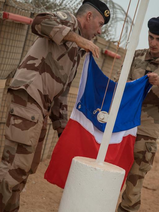 Ein französischer Soldat der Barkhane-Operation beim Einholen der französischen Flagge im Dezember 2021 