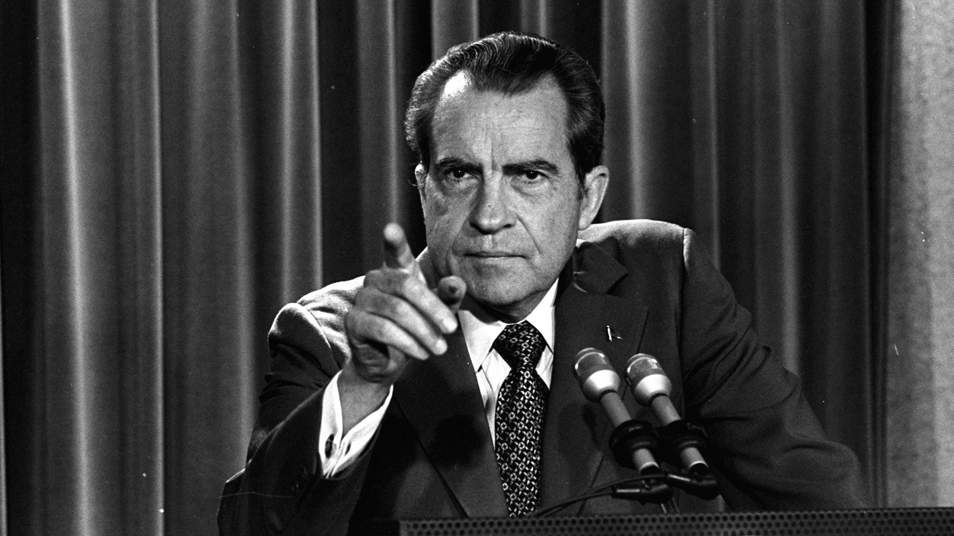 Schwarzweißaufnahme von Präsident Nixon an einem Rednerpult, der mit dem Finger Richtung Publikum zeigt. Schwarzweißaufnahme von Präsident Nixon an einem Rednerpult, der mit dem Finger Richtung Publikum zeigt.