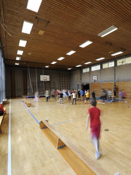 Eine kleine Turnhalle mit Kindern beim Sport.
