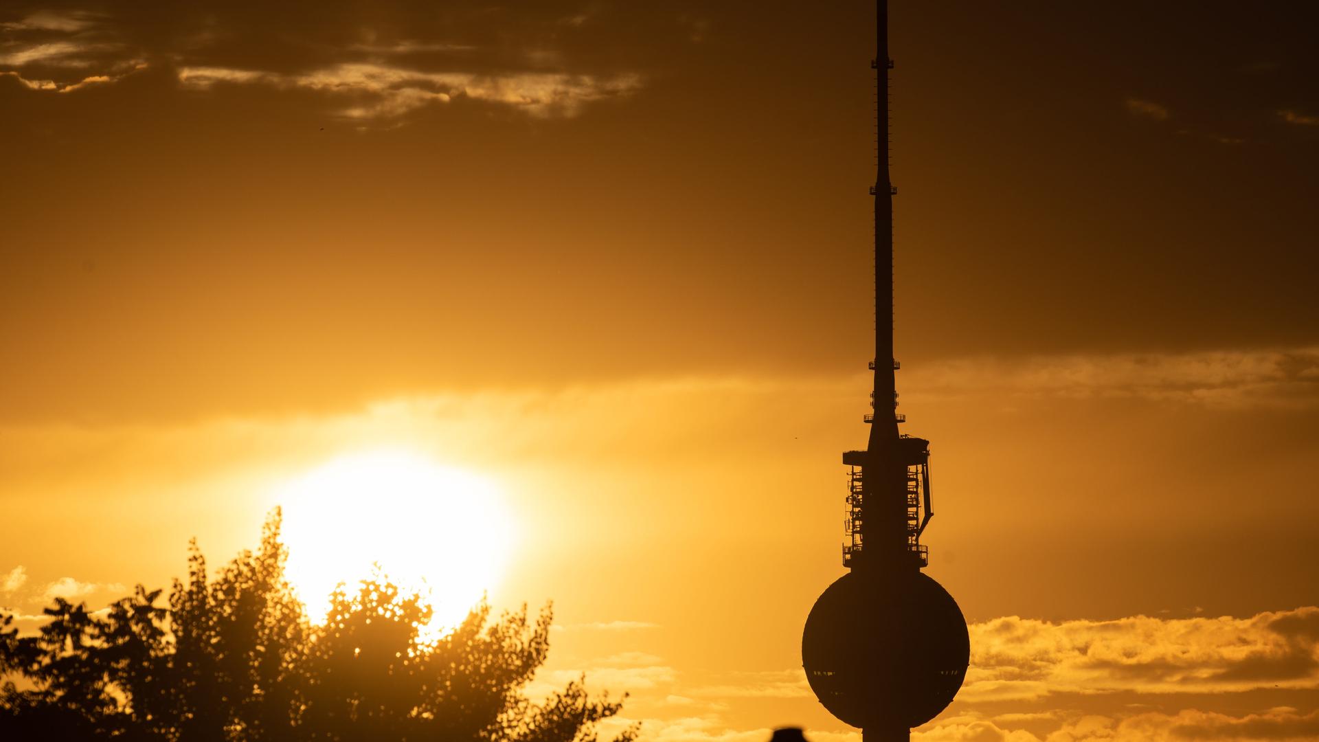 Blick auf den Berliner Fernsehturm an einem heißen Sommerband, im Hintergrund geht die Sonne unter. Blick auf den Berliner Fernsehturm an einem heißen Sommerband, im Hintergrund geht die Sonne unter.