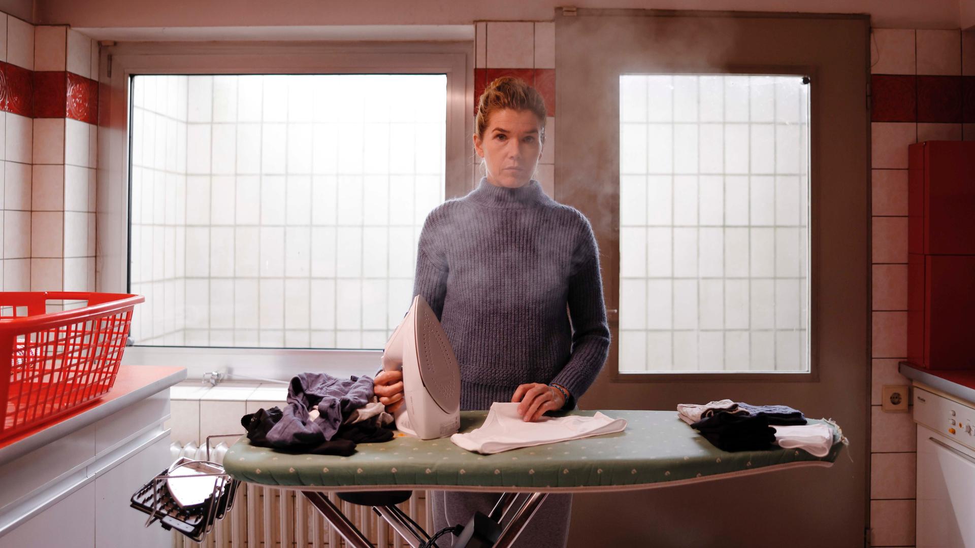 Anke Engelke steht mit einem dampfenden Bügeleisen am Bügelbrett (Szenenbild aus dem Film "Mutter") Anke Engelke steht mit einem dampfenden Bügeleisen am Bügelbrett (Szenenbild aus dem Film "Mutter")