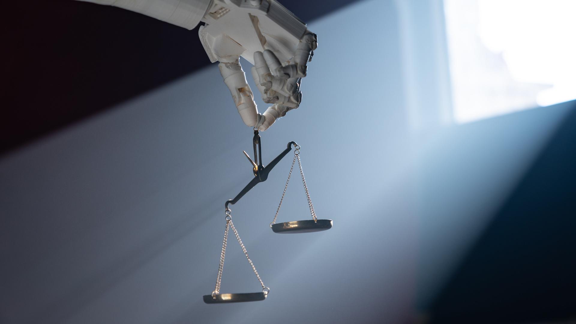 Grafik einer Roboterhand, die eine goldene Waage hält. Grafik einer Roboterhand, die eine goldene Waage hält.