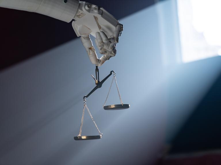 Grafik einer Roboterhand, die eine goldene Waage hält.