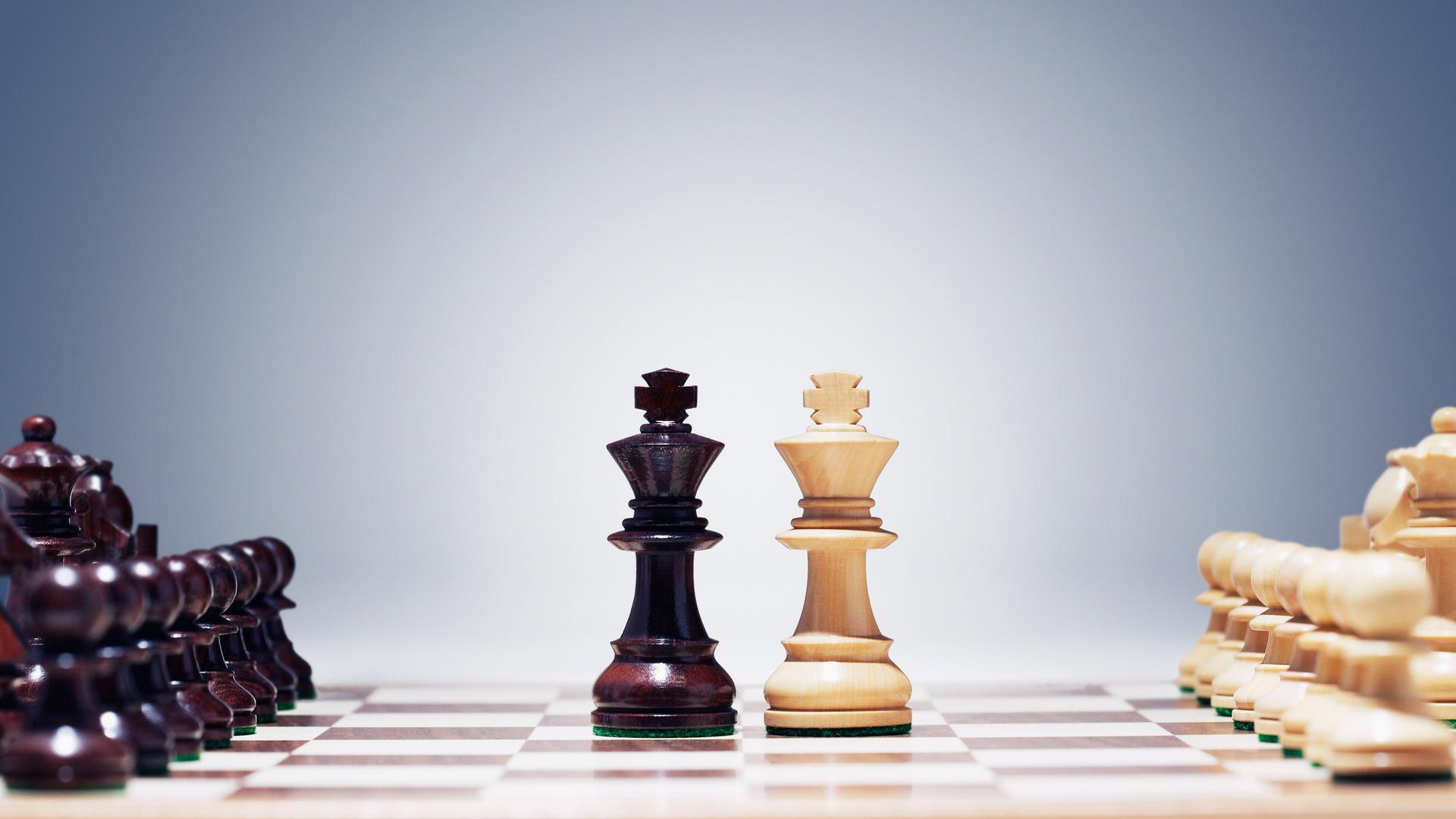 Die beiden Schachkönige stehen in der Mitte des Bretts, rechts und links aufgestellt die weiteren Figuren Die beiden Schachkönige stehen in der Mitte des Bretts, rechts und links aufgestellt die weiteren Figuren