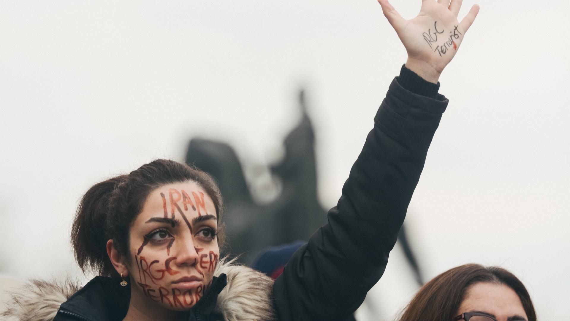 Eine Demonstrantin hält zum Protest gegen die Politik in Iran ihre Hand in die Höhe. Eine Demonstrantin hält zum Protest gegen die Politik in Iran ihre Hand in die Höhe.
