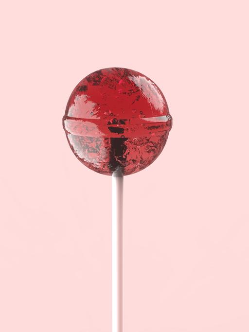 Ein roter Dauerlutscher ist vor einem rosafarbenen Hintergrund zu sehen.