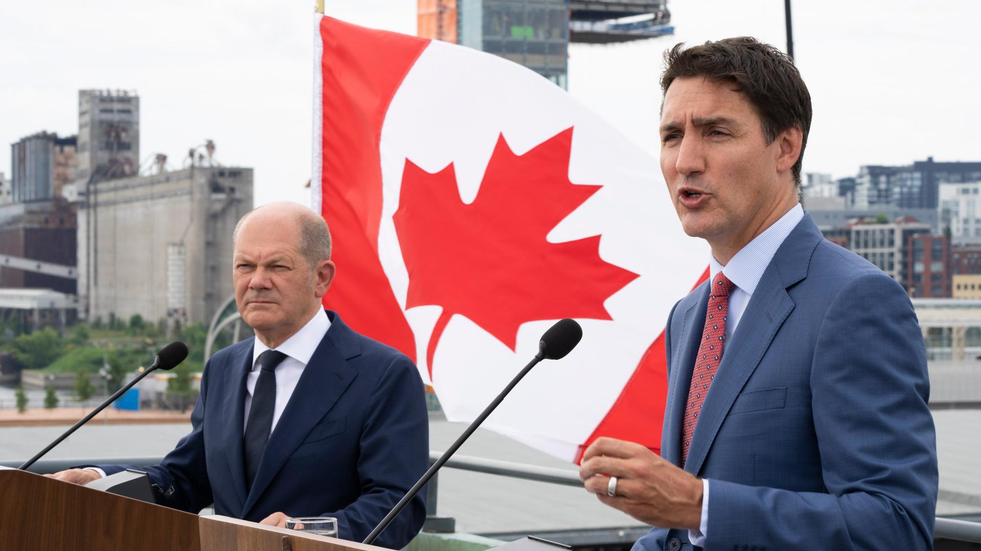 Bundskanzler Olaf Scholz und der kanadische Ministerpräsident Justin Trudeau stehen hinter vRednerpulten. Dahinter weht die Flagge von Kanada. Bundskanzler Olaf Scholz und der kanadische Ministerpräsident Justin Trudeau stehen hinter vRednerpulten. Dahinter weht die Flagge von Kanada.