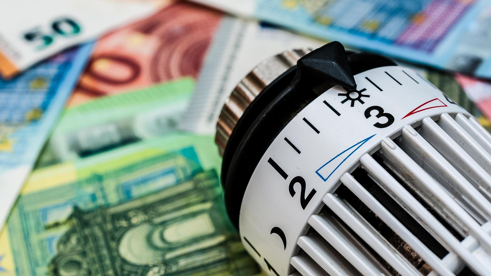 Ein Heizungsthermostat liegt auf Geldscheinen Ein Heizungsthermostat liegt auf Geldscheinen
