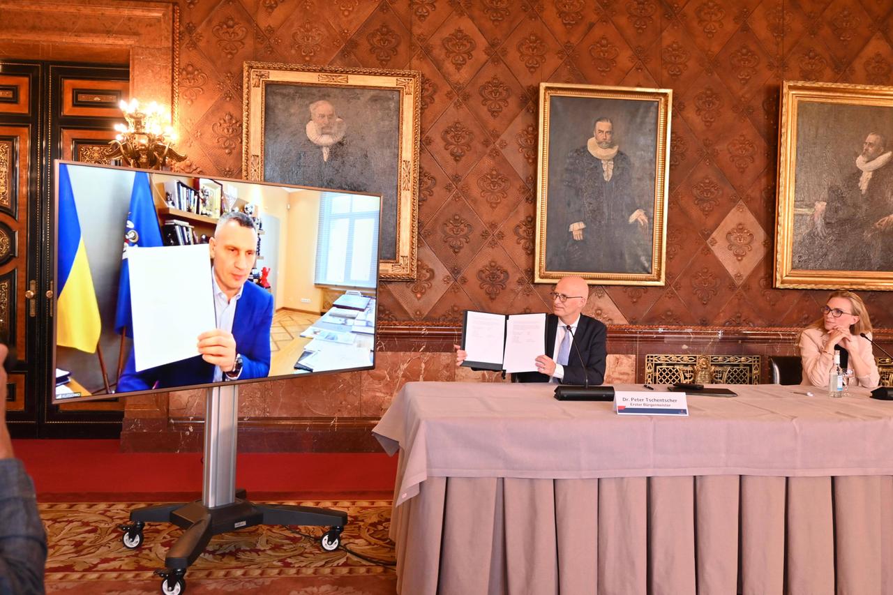 Vitali Klischko und Peter Tschentscher halten ein Dokument hoch. Vitali Klischko und Peter Tschentscher halten ein Dokument hoch.