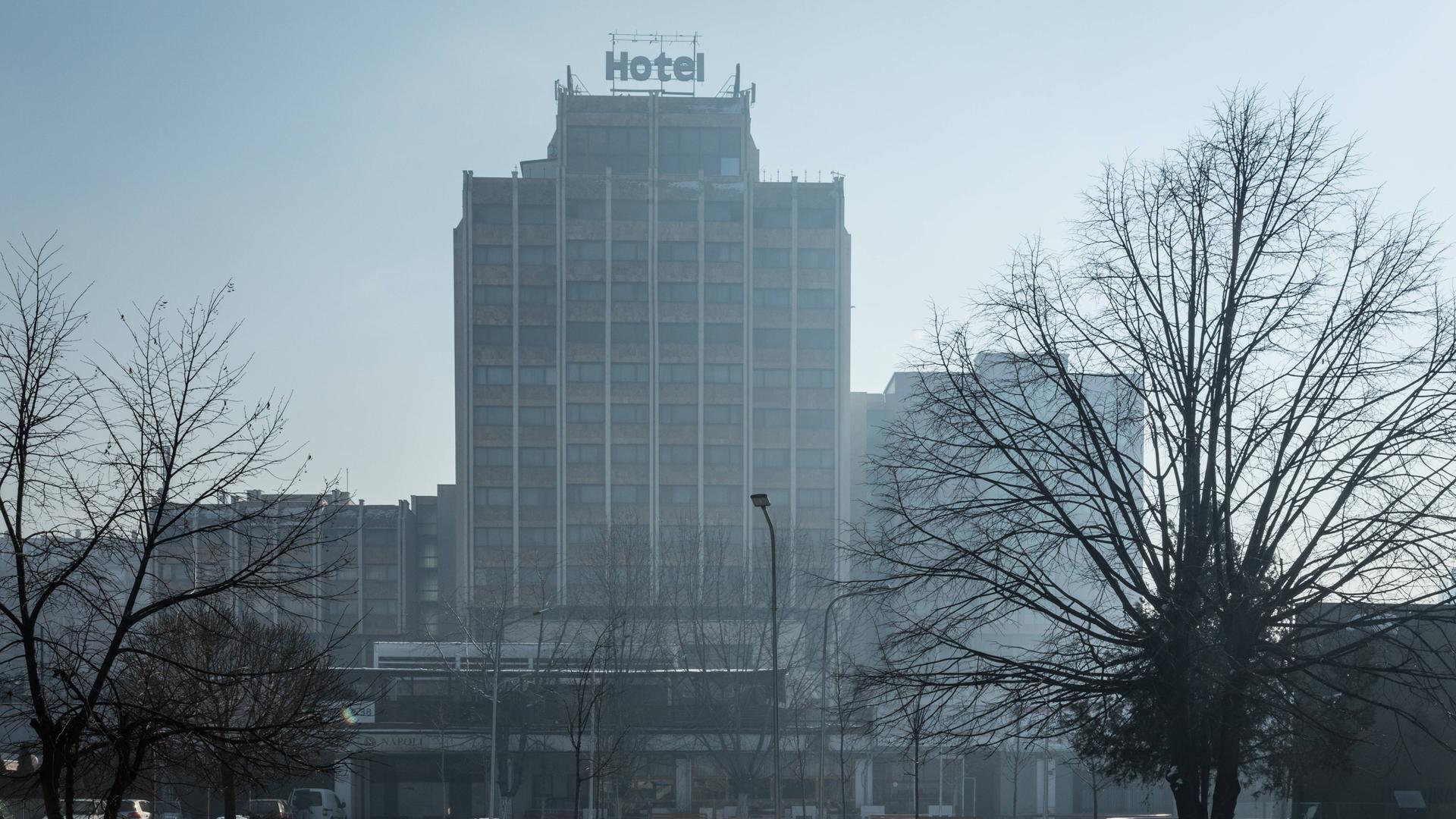 Ein tristes Hochhaus mit der Aufschrift "Hotel" auf dem Dach steht in einer verschneiten Stadt. Ein tristes Hochhaus mit der Aufschrift "Hotel" auf dem Dach steht in einer verschneiten Stadt.