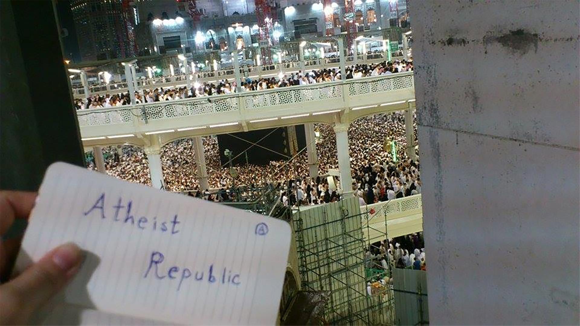 "Atheist Republic" steht auf einem Zettel, im Hintergrund ist eine Menschenmenge in Mekka zu sehen.