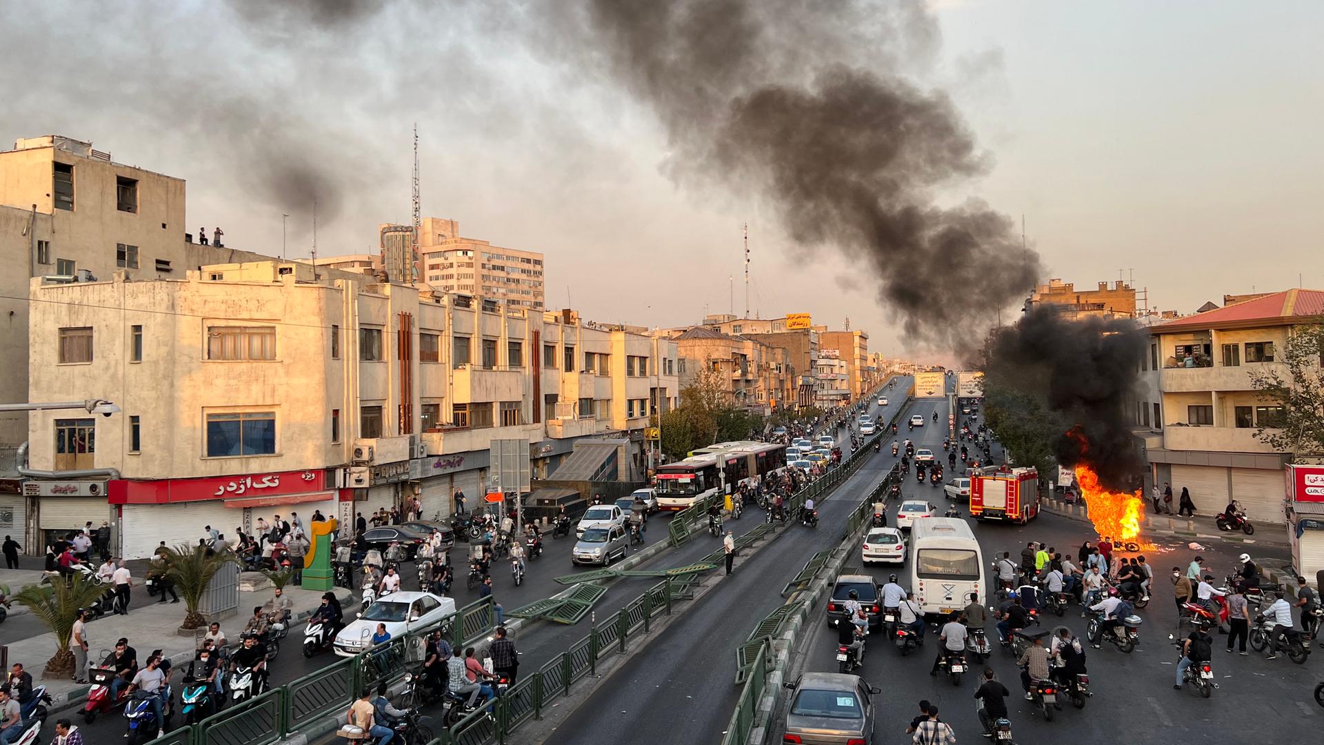 Protest im Iran: Ein Motorrad brennt in Teheran auf der Strasse, Strassenchaos drumherum. Iran, 8. Oktober 2022. Protest im Iran: Ein Motorrad brennt in Teheran auf der Strasse, Strassenchaos drumherum. Iran, 8. Oktober 2022.