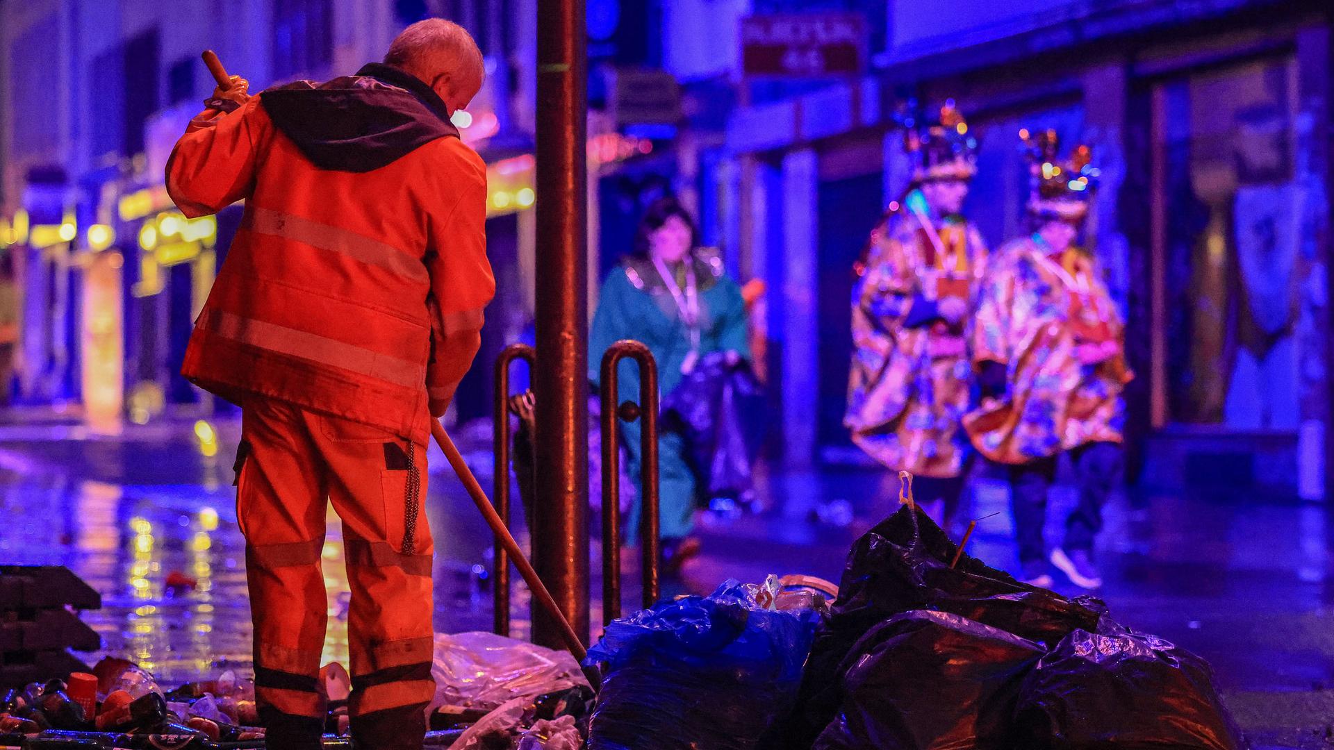 Mitarbeitende der Straßenreinigung fegen den Müll der Karnevalsfeiern auf der Severinsstrasse zusammen. Mitarbeitende der Straßenreinigung fegen den Müll der Karnevalsfeiern auf der Severinsstrasse zusammen.