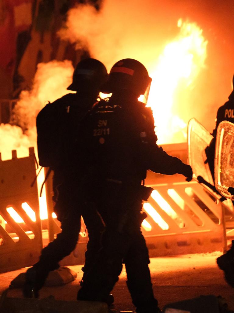 Polizisten gehen an einer brennenden Barrikade im Leipziger Stadtteil Connewitz vorbei, wo es zu Ausschreitungen gekommen ist. 