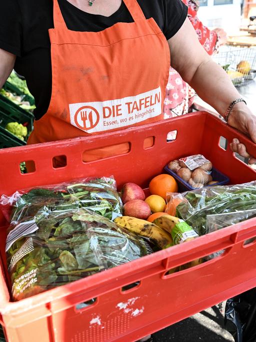 Eine Person mit einer Tafel-Schürtze in einem Tafel-Laden.