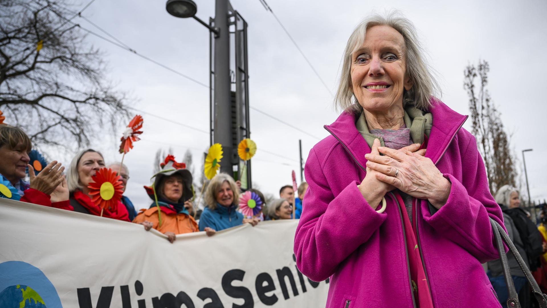 Rosmarie Wydler-Wälti, Co-Präsidentin des Vereins „Klimaseniorinnen Schweiz“ - eine ältere Frau mit grauem, halblangen Haar in pinker Jacke lächelt bei einem Protest in die Kamera. Rosmarie Wydler-Wälti, Co-Präsidentin des Vereins „Klimaseniorinnen Schweiz“ - eine ältere Frau mit grauem, halblangen Haar in pinker Jacke lächelt bei einem Protest in die Kamera.