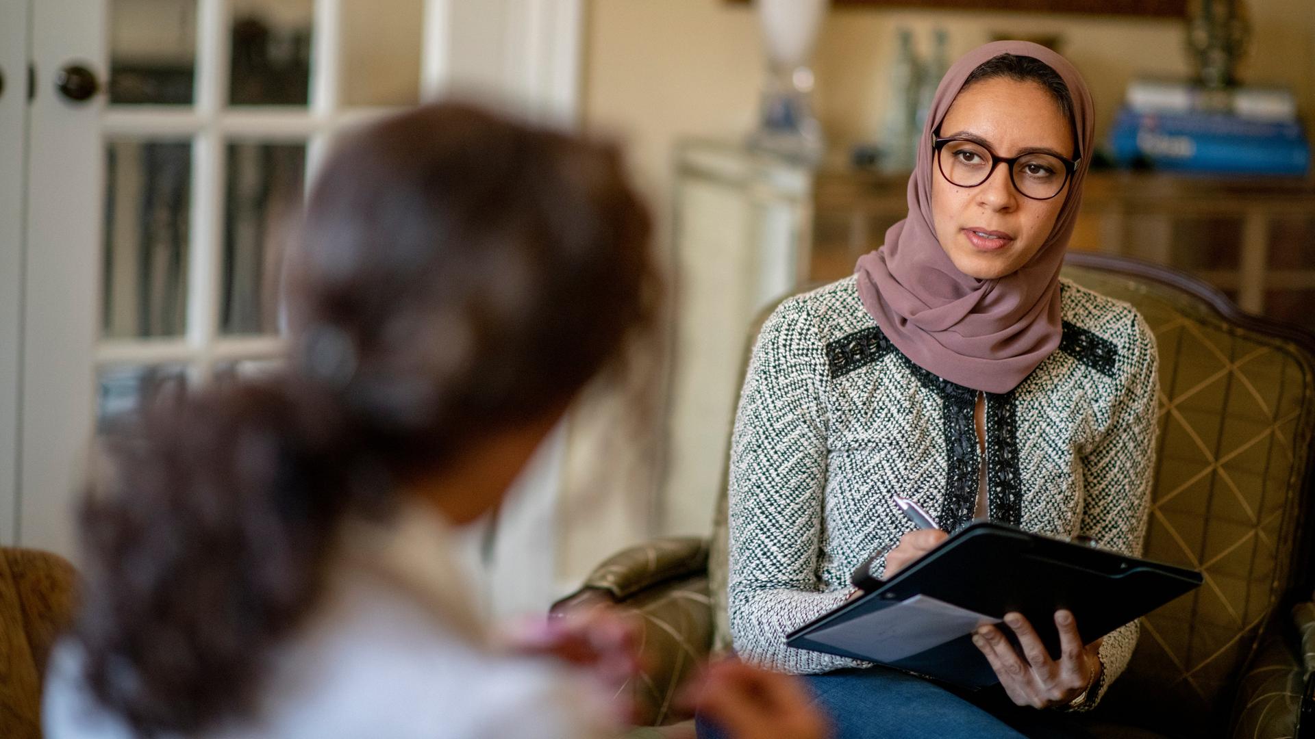 In einer Therapiesitzung berät eine muslimische Ärztin ihre Patientin.