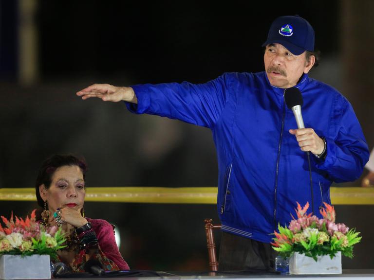 Nicaraguas Präsident Daniel Ortega mit blauer Jacke und Mütze neben seiner Frau