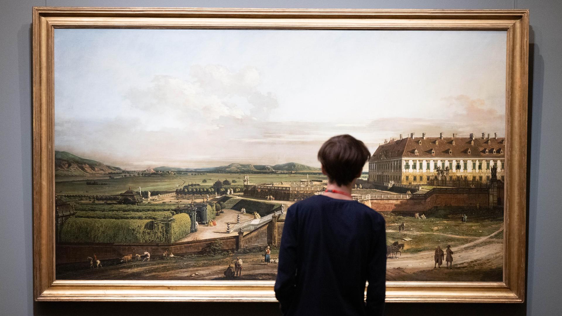 Ein Mann steht vor dem Ölgemälde „Das kaiserliche Lustschloss Schloss Hof Ansicht von Norden, 1759-60“ von Bernardo Bellotto. Ein Mann steht vor dem Ölgemälde „Das kaiserliche Lustschloss Schloss Hof Ansicht von Norden, 1759-60“ von Bernardo Bellotto.