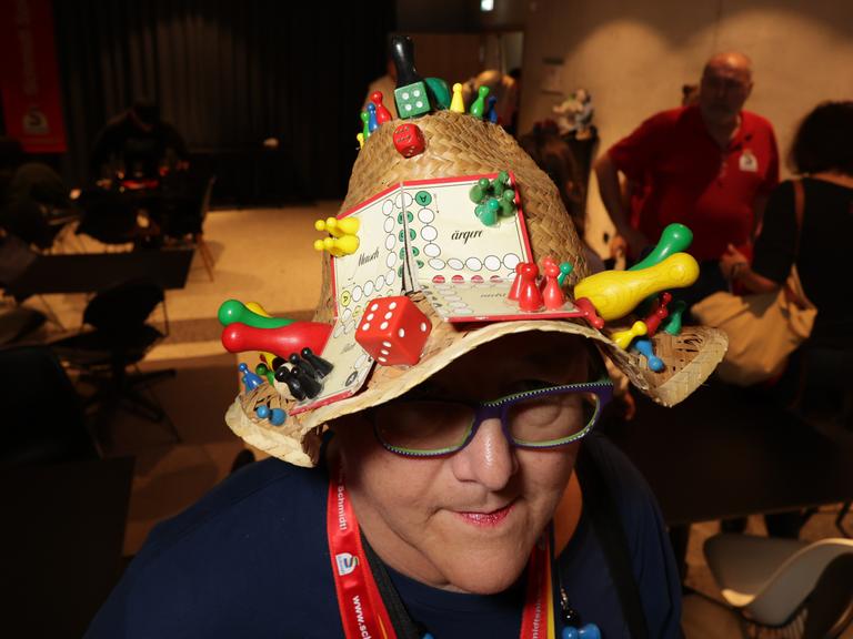 Eine WM-Teilnehmerin trägt einen mit Spielfiguren besetzten Strohhut.