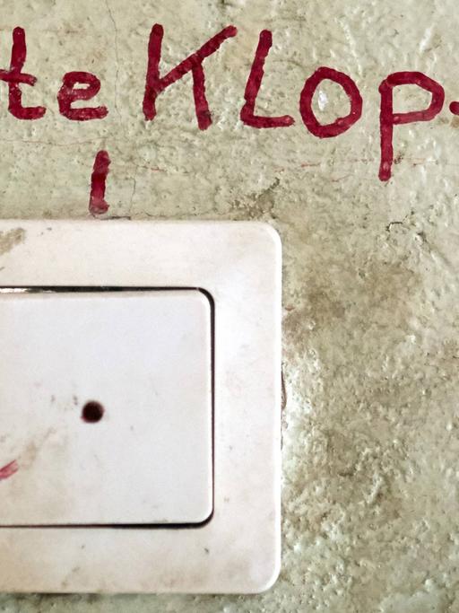 Unfassbare Vorkommnisse während eines Entmietungsprozesses - erzählt von betroffenen Bewohnern. Zu sehen: Eine Haustürklingel an einer Wand mit einem Schriftzug "Bitte klopfen" darüber. 