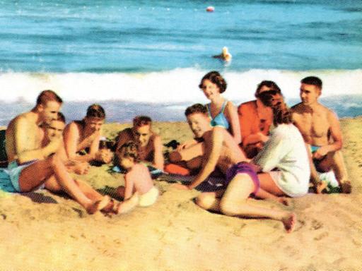 Ein altes Familienfoto einer Grossfamilie am Strand wie aus der Werbung.