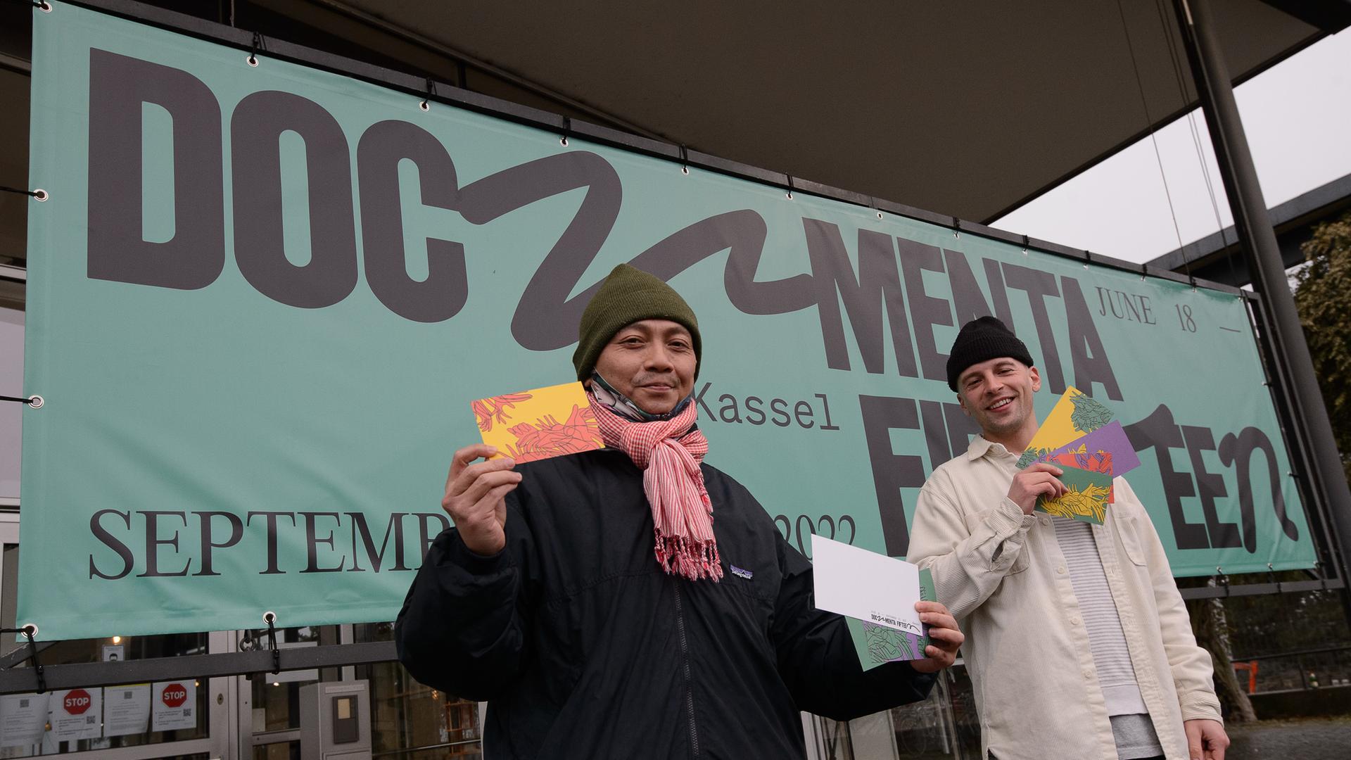 Reza Afisina (links) vom Kuratorenkollektiv Ruangrupa und Leon Schniewind, Inhouse Desinger bei der documenta, stehen mit Grußkarten bei der Vorstellung des neuen Logo der documenta fifteen. Reza Afisina (links) vom Kuratorenkollektiv Ruangrupa und Leon Schniewind, Inhouse Desinger bei der documenta, stehen mit Grußkarten bei der Vorstellung des neuen Logo der documenta fifteen.