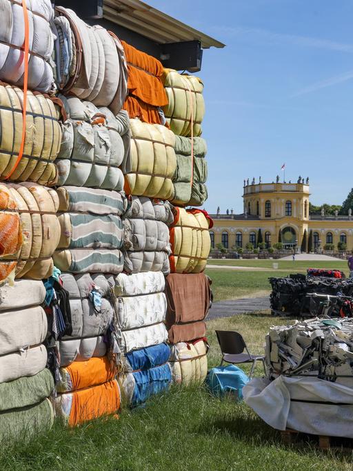 The Nest Collective aus Nairobi macht mit "Return to Sender", einer begehbaren Installation aus Müll, auf den Transport von Müll, Elektroschrott und Textilien in die Länder des Globalen Südens aufmerksam, die dort zur Zerstörung der Umwelt und der Ökonomie beitragen.
