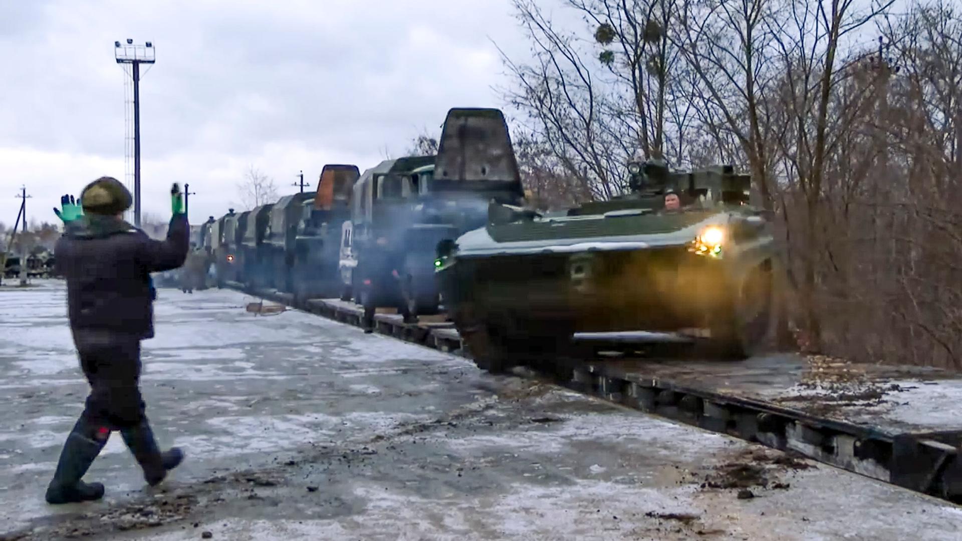 Russische Militärfahrzeuge in einer langen Reihe fahren von einer Transportplattform. Russische Militärfahrzeuge in einer langen Reihe fahren von einer Transportplattform.