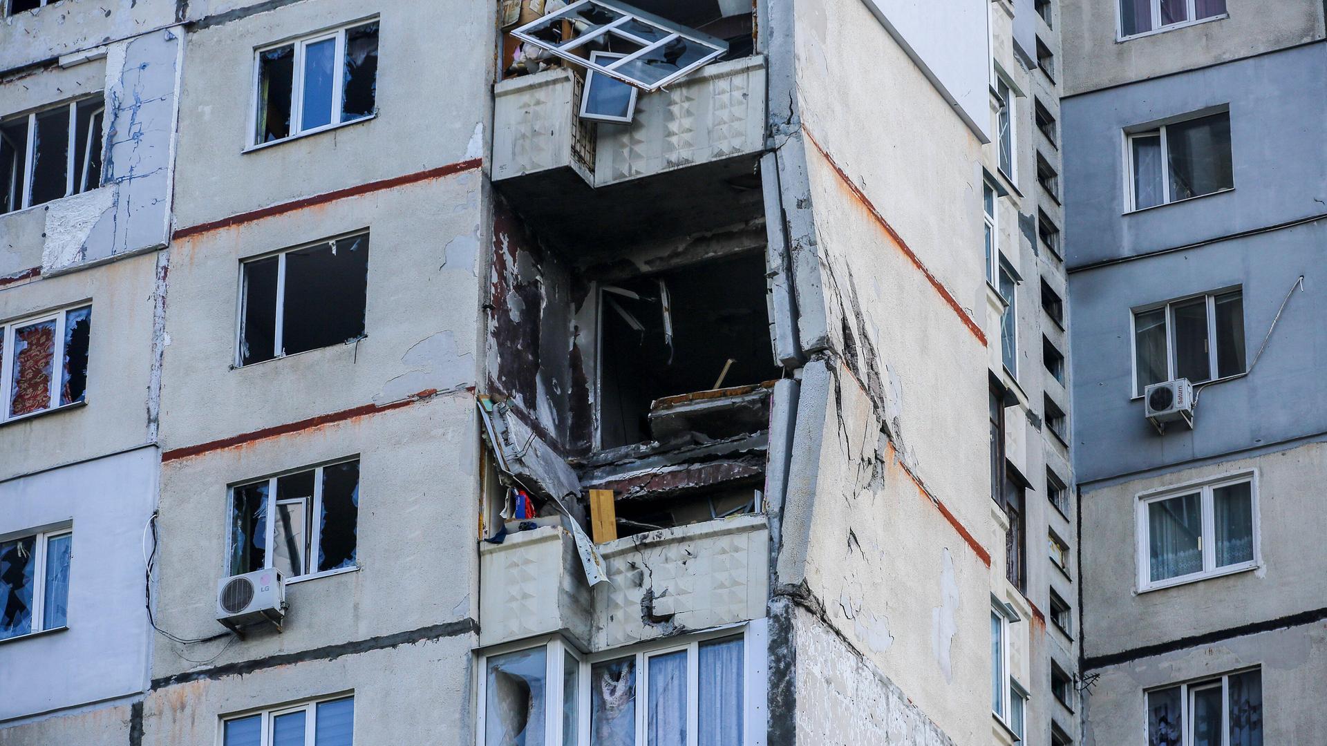 An einem Wohnhaus in Charkiw sind Fenster und Balkone teilweise zerstört. An einem Wohnhaus in Charkiw sind Fenster und Balkone teilweise zerstört.