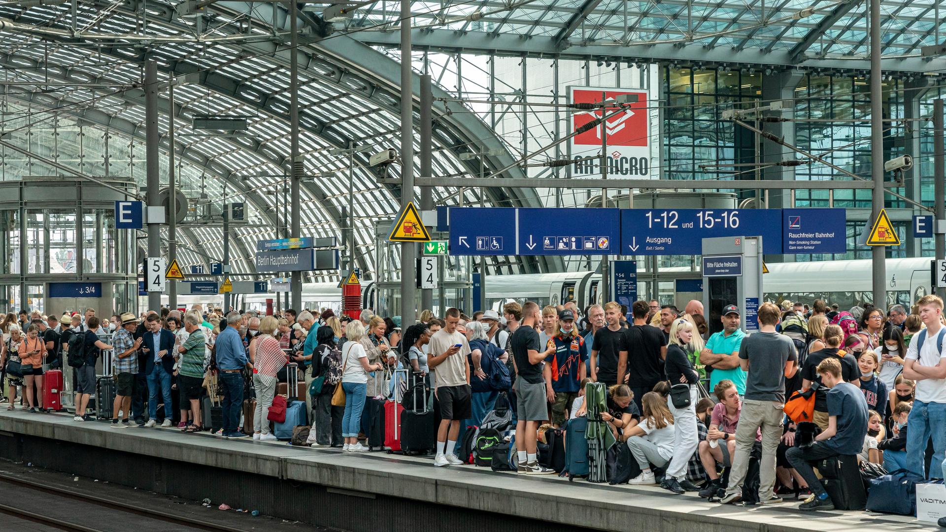Reisende auf dem Berliner Hauptbahnhof drängeln sich auf einem Bahnsteig und warten auf den Zug. Reisende auf dem Berliner Hauptbahnhof drängeln sich auf einem Bahnsteig und warten auf den Zug.