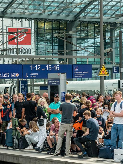 Reisende auf dem Berliner Hauptbahnhof drängeln sich auf einem Bahnsteig und warten auf den Zug.