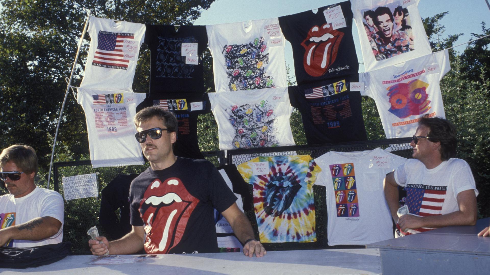 Merchandise-Stand mit Band-Shirts unter anderem mit der ikonischen Zunge der Rolling Stones auf einer Konzert-Tournee 1989 in den USA. Merchandise-Stand mit Band-Shirts unter anderem mit der ikonischen Zunge der Rolling Stones auf einer Konzert-Tournee 1989 in den USA.