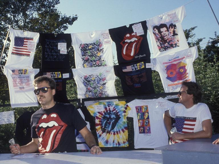 Merchandise-Stand mit Band-Shirts unter anderem mit der ikonischen Zunge der Rolling Stones auf einer Konzert-Tournee 1989 in den USA. 