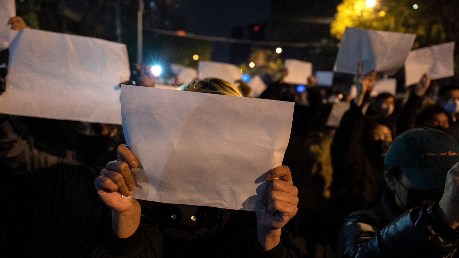 In Peking halten Menschen leere weiße Papiere in die Höhe. Der Protest richtet sich gegen die Regierung. In Peking halten Menschen leere weiße Papiere in die Höhe. Der Protest richtet sich gegen die Regierung.