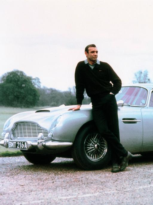 Sean Connery vor seinem Aston Martin in "James Bond: Goldfinger" 1964 