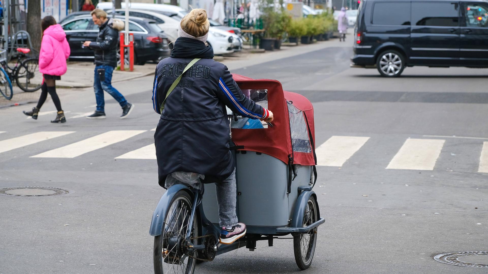 Eine Frau fährt auf einem Lastenfahrrad in Düsseldorf.