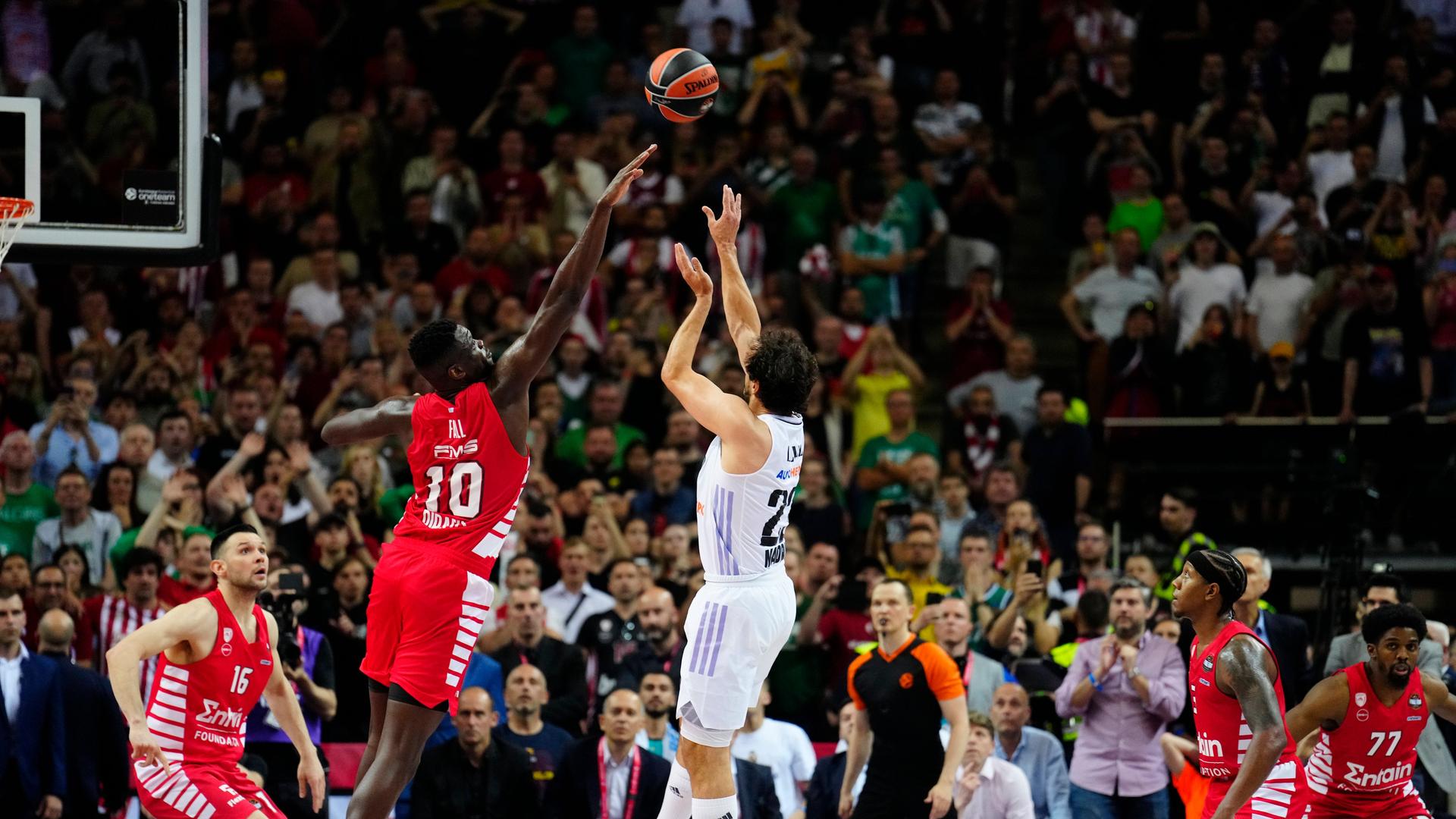 Sergio Llull wirft den Ball über einen Verteidiger. Sergio Llull wirft den Ball über einen Verteidiger.