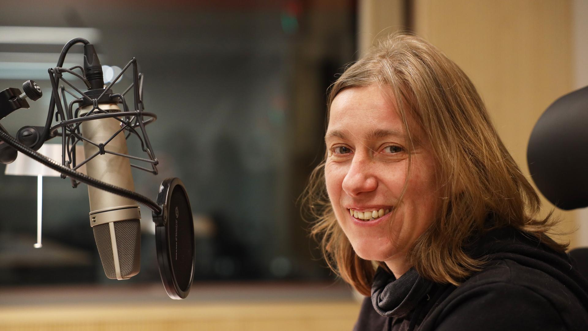Nadine Dobler sitzt vor einem Mikrofon im Studio Nadine Dobler sitzt vor einem Mikrofon im Studio