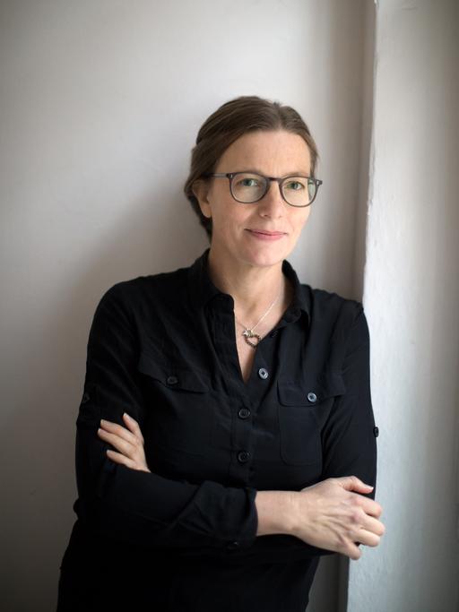 Sally McGrane lehnt an einer Wand