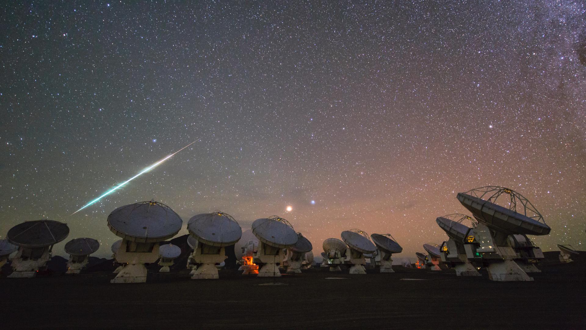 : In diesen Nächten sind wieder vermehrt Sternschnuppen zu sehen – mit Glück auch so helle wie diese hier über der Teleskopanlage ALMA in Chile. 