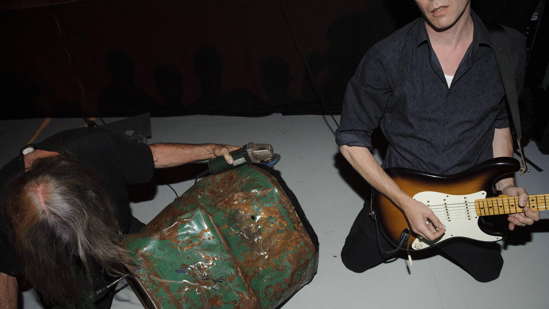 Musiker spielen auf Gitarren und auf Autotüren. Musiker spielen auf Gitarren und auf Autotüren.