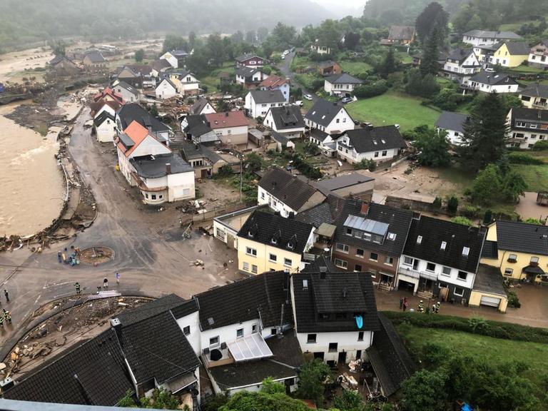 Luftbild des Dorfes auf dem intakte Häuser aber auch Schlamm und überflutete Bereiche zu sehen sind. Luftbild des Dorfes auf dem intakte Häuser aber auch Schlamm und überflutete Bereiche zu sehen sind.