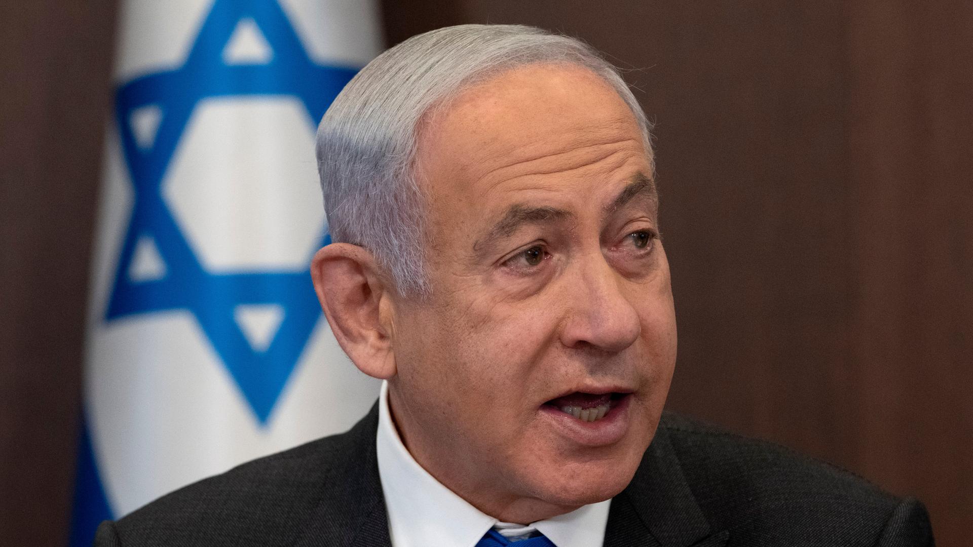 Israels Premierminister Benjamin Netanjahu vor einer Flagge seines Landes