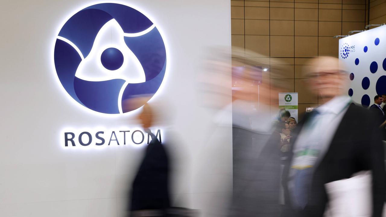 Ein Messestand des Konzerns Rosatom zeigt das Logo des Unternehmens. Im Vordergrund sind unscharf Passanten zu erkennen.