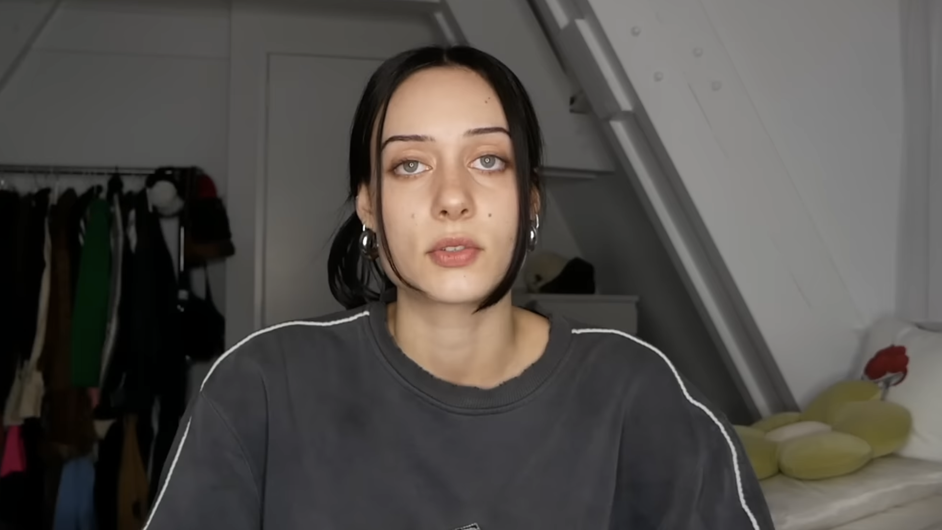 Die YouTuberin Kayla Shyx sitzt in einem Zimmer und spricht frontal in die Kamera. Sie trägt einen grauen Pulli.