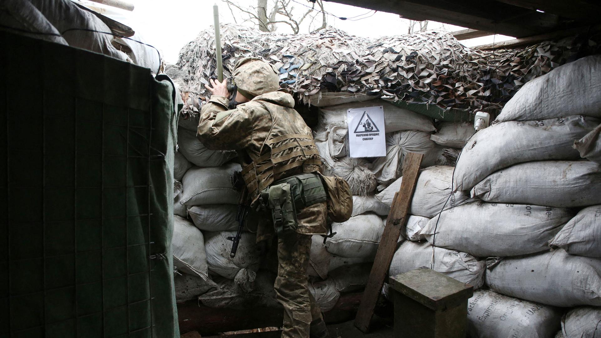 Ein Ukrainer beobachtet durch ein Fernrohr die Frontlinie zu Russland in der Nähe von Pesky, Donetsk am 14. Dezember 2021. Ein Ukrainer beobachtet durch ein Fernrohr die Frontlinie zu Russland in der Nähe von Pesky, Donetsk am 14. Dezember 2021.