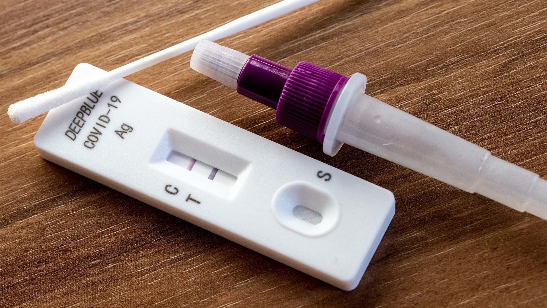 Auf einer Holzunterlage liegt ein positiver Coronatest Auf einer Holzunterlage liegt ein positiver Coronatest